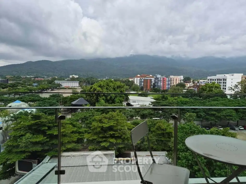 Stunning balcony view overlooking lush greenery and distant mountains, perfect for serene living.