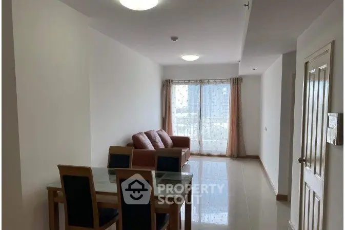 Spacious living room with modern furniture and natural light in a high-rise apartment.