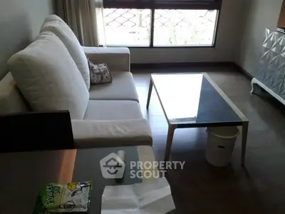 Cozy living room with modern sofa and glass coffee table, perfect for relaxation.