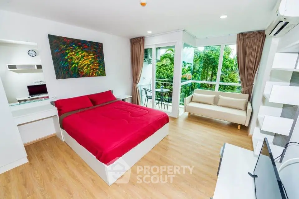 Spacious modern bedroom with vibrant decor and lush garden view, featuring a cozy seating area and large windows.
