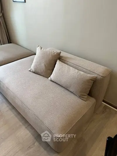 Modern beige sofa in stylish living room with wooden flooring