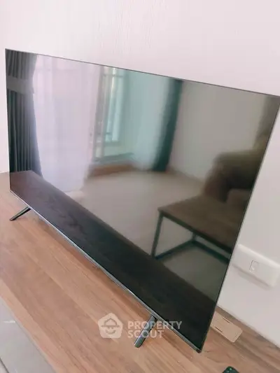 Modern living room with sleek flat-screen TV and elegant wooden table