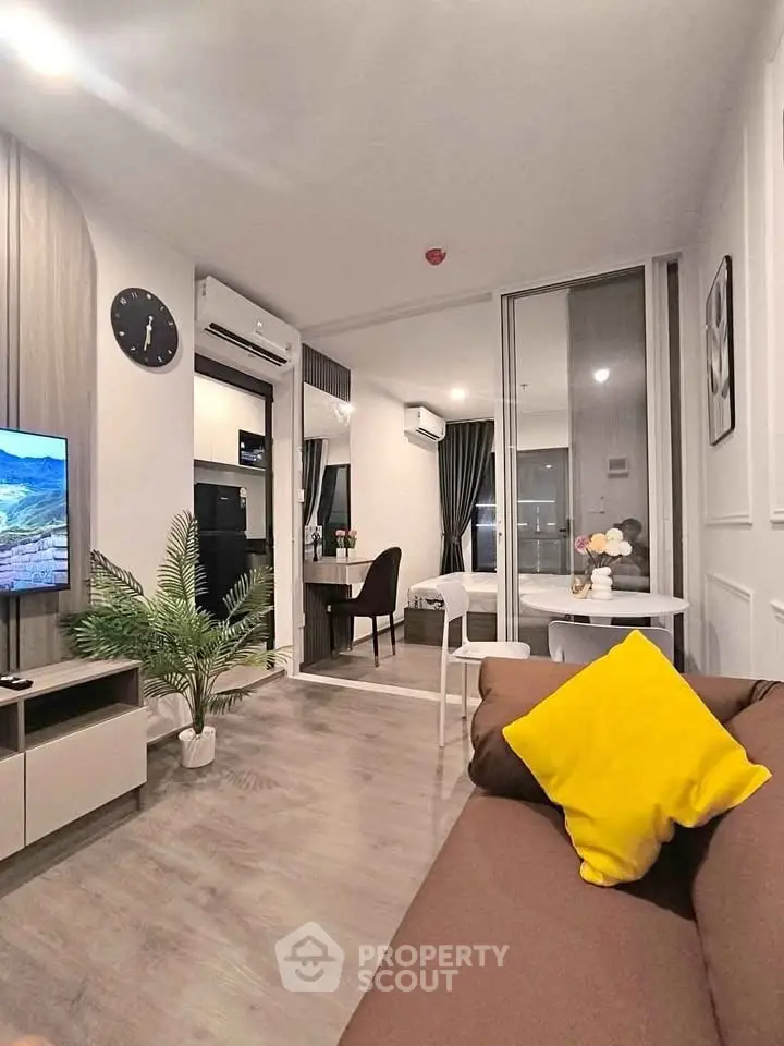 Modern living room with stylish decor and open layout, featuring a cozy sofa and dining area.