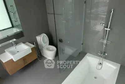Modern bathroom with sleek design featuring bathtub and glass shower enclosure.