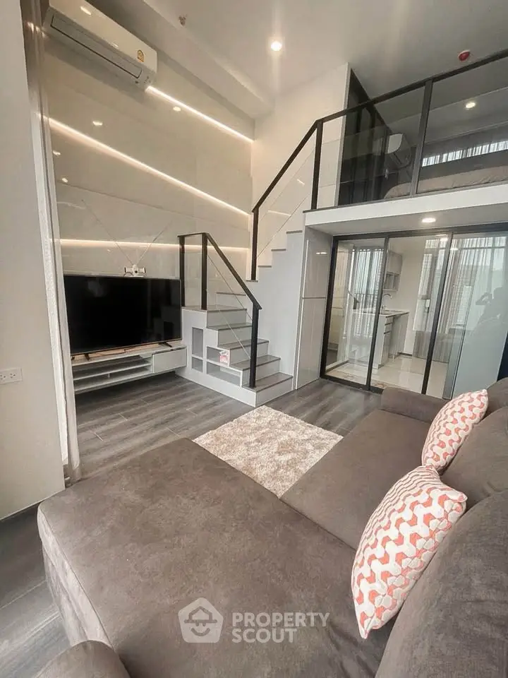 Modern living room with loft design, sleek staircase, and stylish decor in a contemporary apartment.