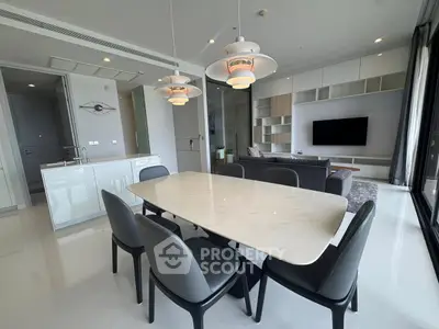 Modern open-plan living and dining area with sleek furnishings and elegant lighting.