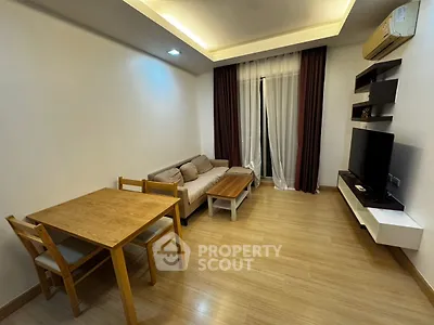 Modern living room with cozy sofa, dining table, and wall-mounted TV in a stylish apartment.