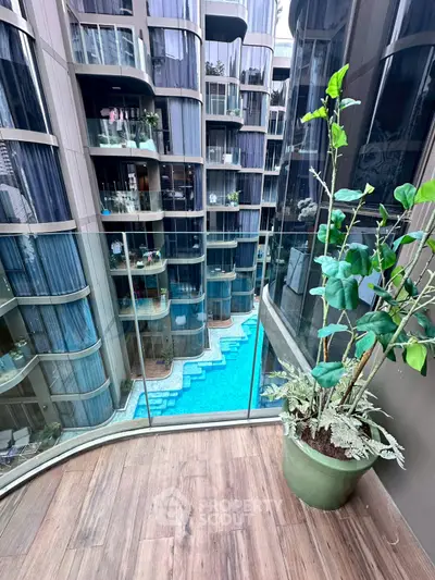 Luxurious apartment balcony with stunning pool view and modern architecture.