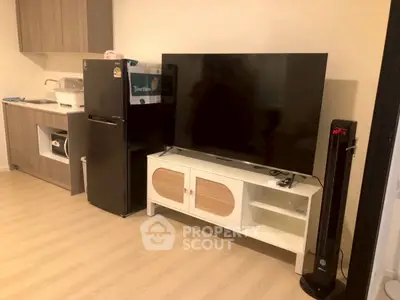 Modern living room with sleek TV setup and compact kitchen area