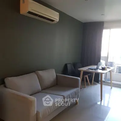 Modern living room with sofa, air conditioning, and dining area near window.