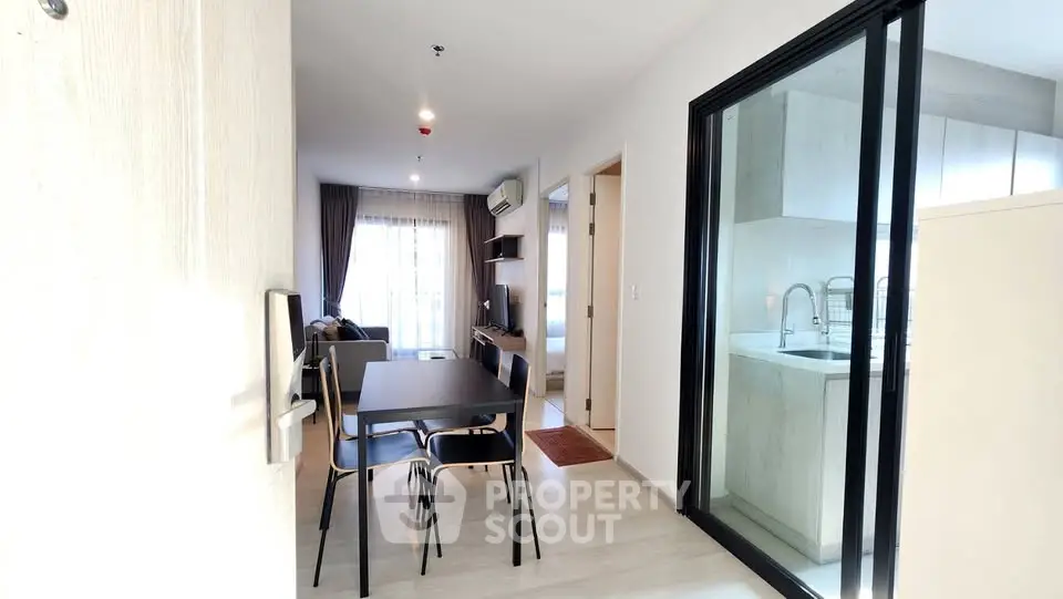 Modern apartment interior with open layout, dining area, and kitchen view.