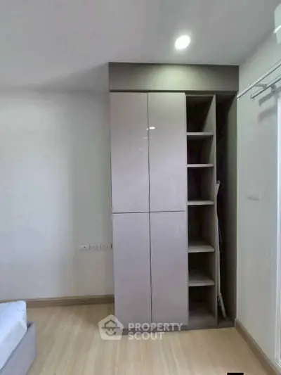 Modern bedroom with sleek built-in wardrobe and cozy wooden flooring.