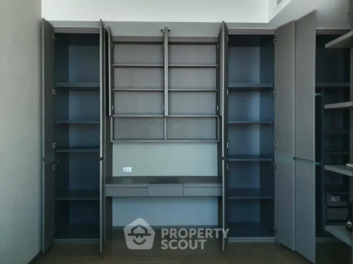 Spacious built-in storage unit with open shelves and cabinets in modern home.