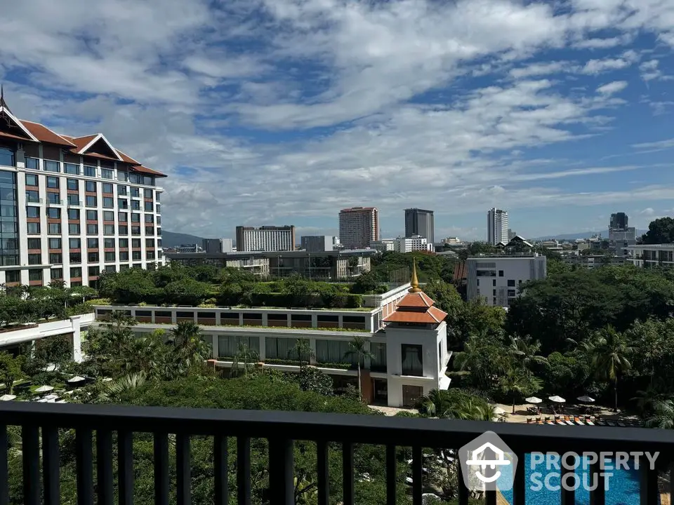 Stunning cityscape view from a high-rise balcony overlooking lush greenery and a pool.