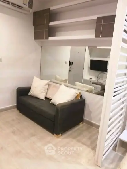 Modern living room with sleek sofa and stylish shelving in a compact space.