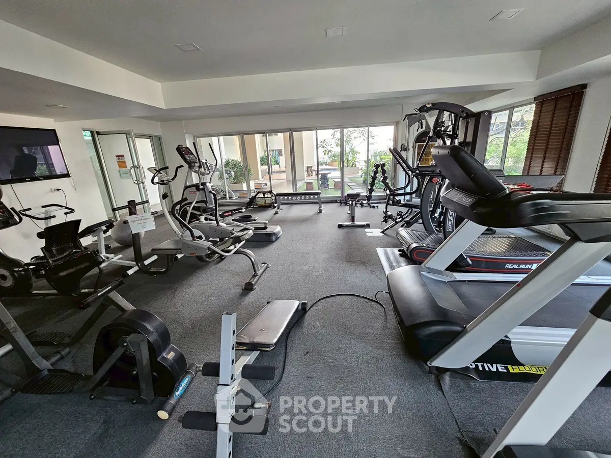 Modern gym with state-of-the-art equipment and large windows for natural light.