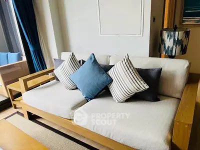 Stylish living room with modern wooden sofa and plush cushions, perfect for relaxation and comfort.