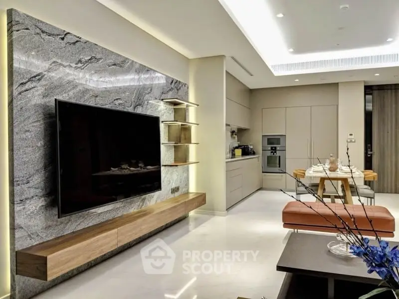 Luxurious modern living room with sleek kitchen, marble TV wall, and elegant dining area.