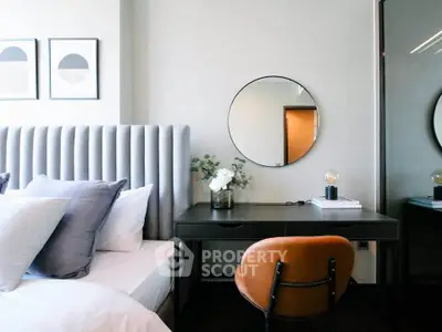 Stylish bedroom with modern decor, featuring a plush bed, elegant mirror, and chic desk setup.