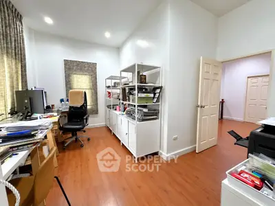 Spacious home office with modern furniture and ample natural light, perfect for productivity and comfort.
