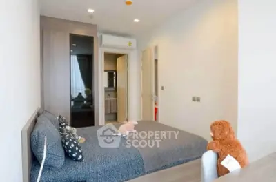 Cozy bedroom with modern decor and plush toys, featuring a stylish bed and ample natural light.