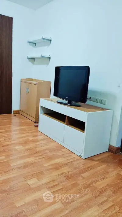 Modern living room with wooden flooring and sleek TV stand, perfect for cozy evenings.