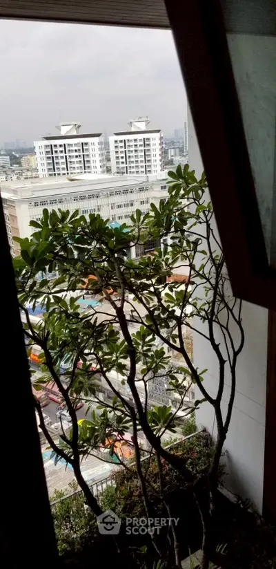 Stunning city view from a high-rise balcony with lush greenery enhancing urban living.