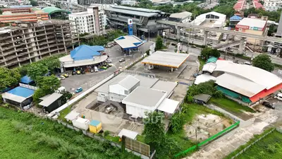 Aerial view of urban area with gas station and surrounding buildings.