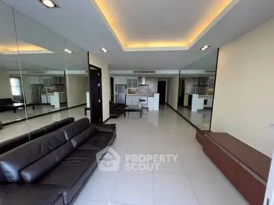 Spacious modern living room with sleek design and mirrored walls