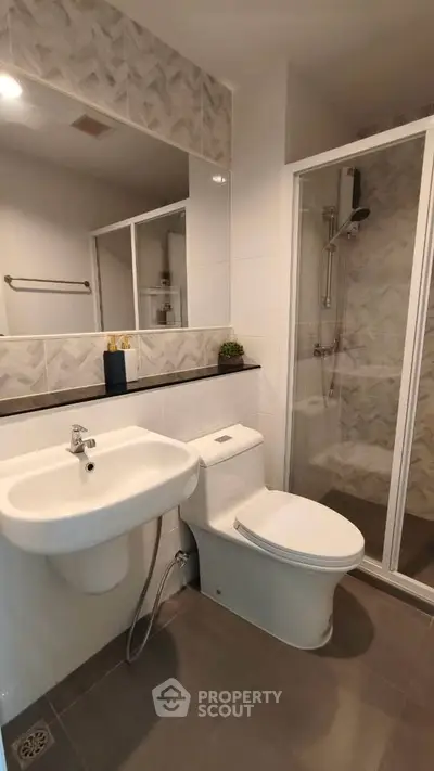 Modern bathroom with sleek fixtures and glass shower enclosure