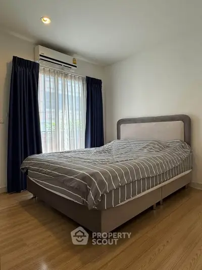 Cozy bedroom with modern decor and natural light, featuring a comfortable bed and stylish curtains.