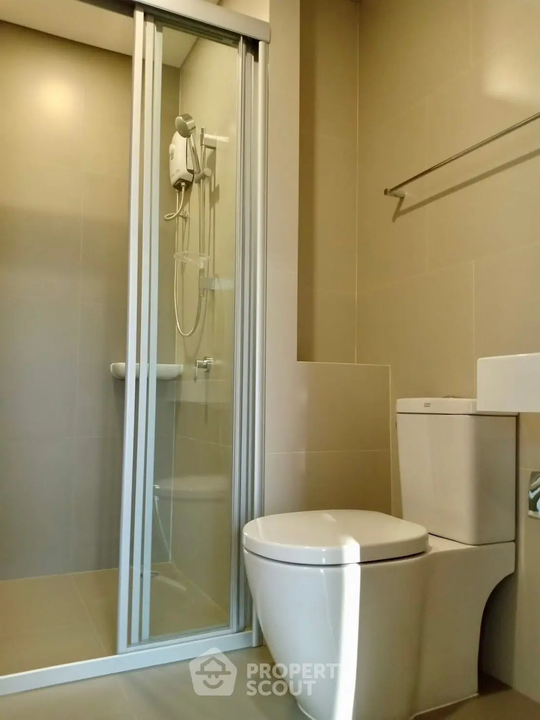 Modern bathroom with sleek shower and toilet in neutral tones.