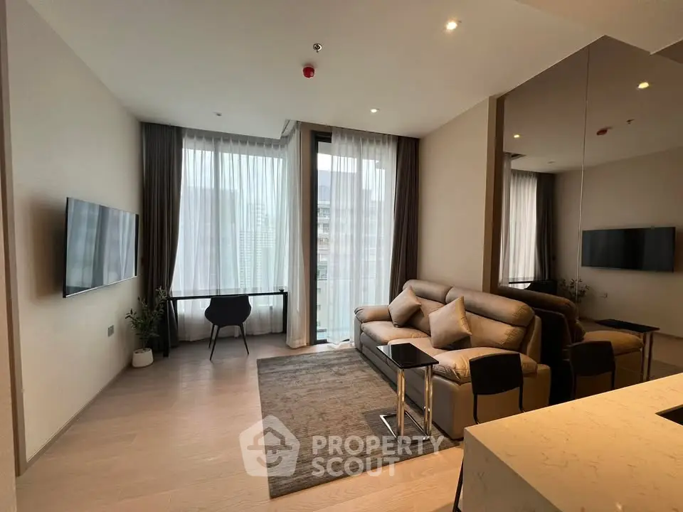 Modern living room with sleek furniture and large windows offering natural light.