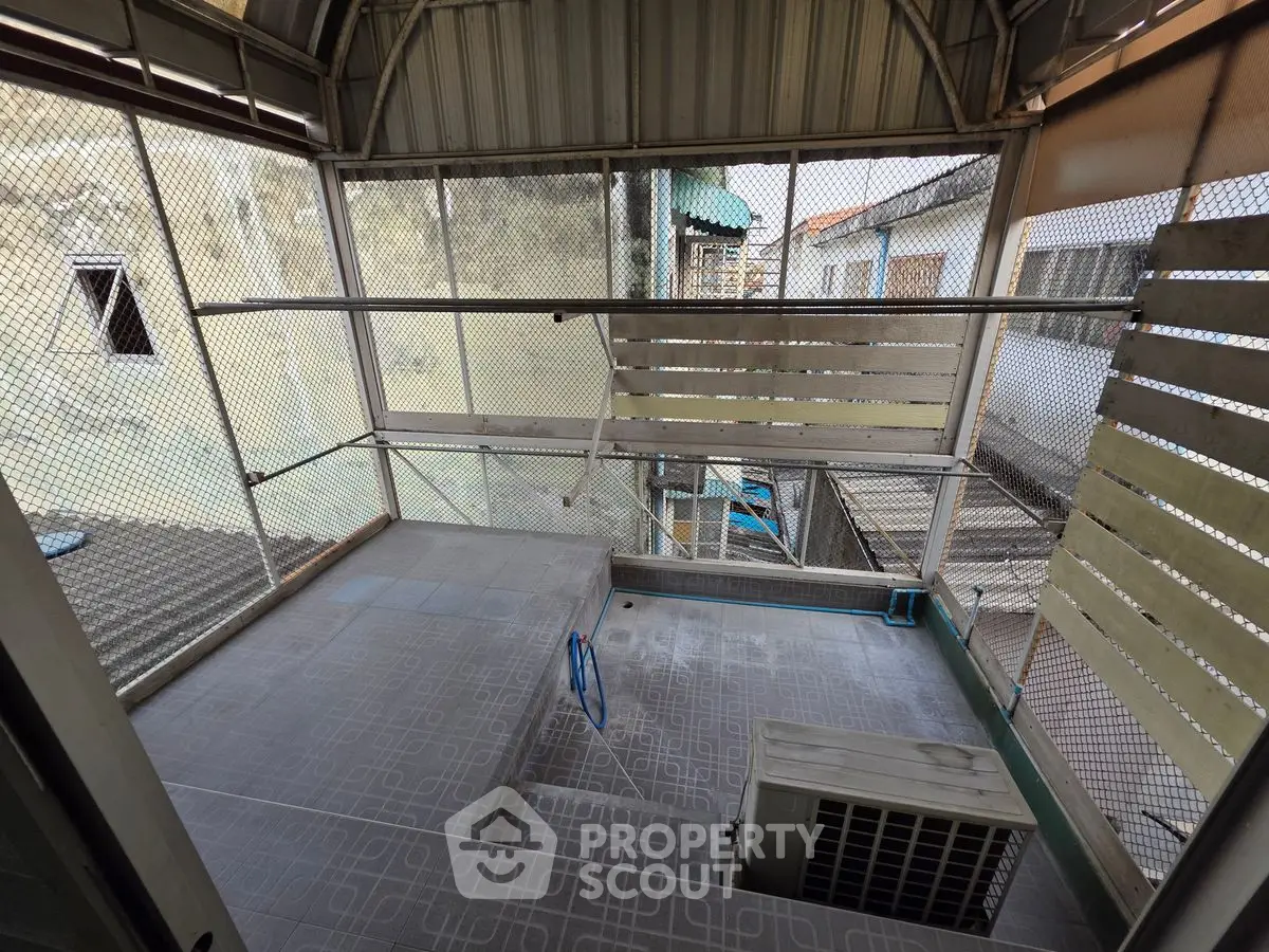 Spacious balcony with metal railing and tiled flooring, perfect for outdoor relaxation.