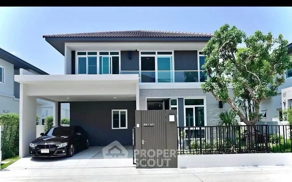 Modern two-story house with sleek design and spacious driveway in a serene neighborhood.