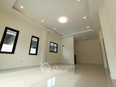 Spacious modern living room with recessed lighting and large windows