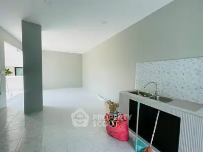 Spacious unfurnished room with tiled floor and modern sink, ideal for customization.
