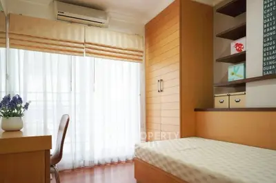 Cozy bedroom with natural light and modern wooden furnishings