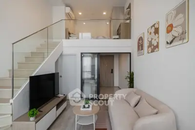 Modern loft-style living room with mezzanine, sleek staircase, and cozy seating area.