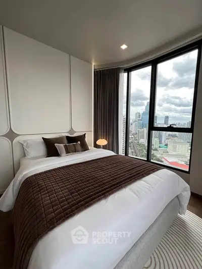 Luxurious bedroom with stunning city view from large windows, featuring elegant decor and cozy bedding.