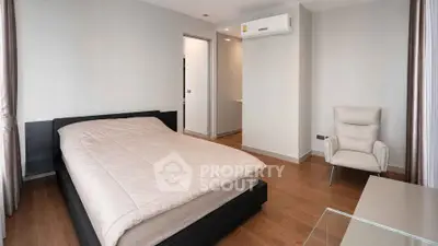 Modern bedroom with sleek design and cozy ambiance, featuring a comfortable bed and stylish armchair.