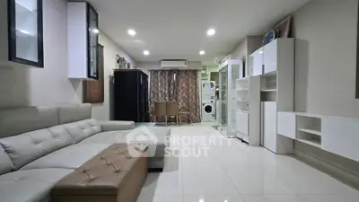 Modern living room with sleek furniture and washing machine in open layout