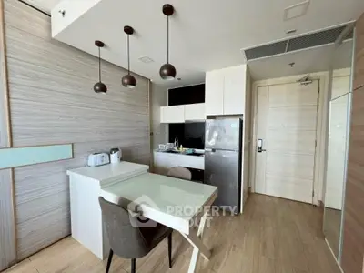Modern kitchen with sleek design, featuring stainless steel appliances and stylish pendant lighting.