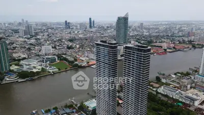 Stunning aerial view of modern high-rise buildings by the river in a bustling cityscape.
