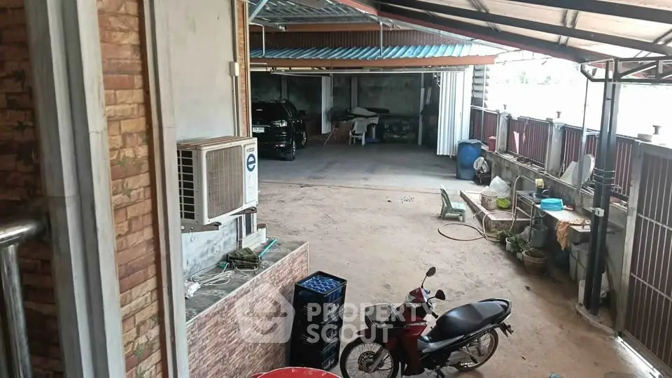 Spacious covered parking area with motorbike and car, ideal for multiple vehicles.