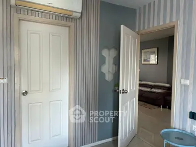 Stylish interior with modern decor and open door leading to cozy living area.