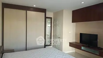 Modern bedroom with built-in wardrobe and wall-mounted TV, perfect for comfortable living.