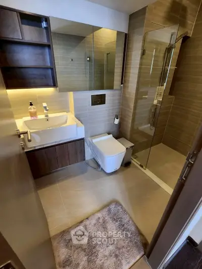 Modern bathroom with glass shower and sleek fixtures in a contemporary apartment.