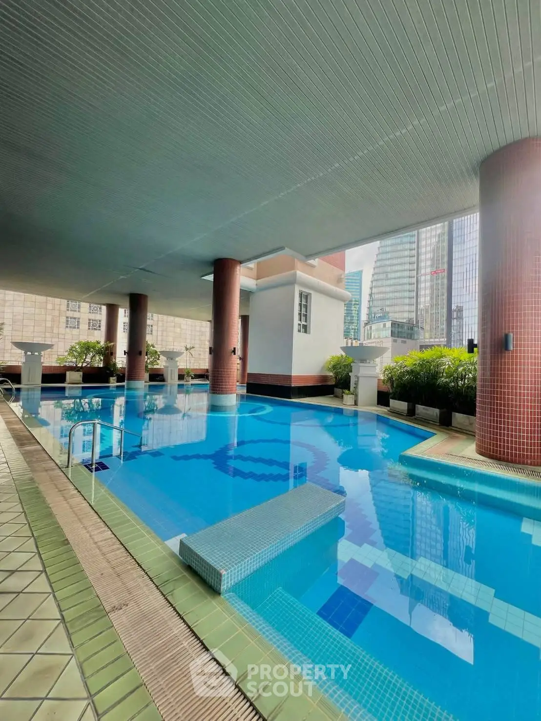 Luxurious residential building with modern pool and cityscape view, perfect for urban living.