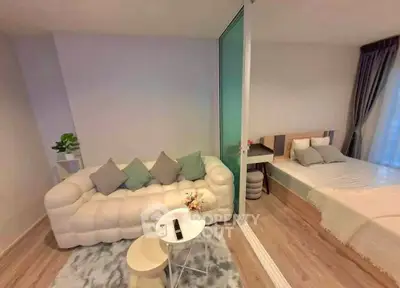 Modern studio apartment with cozy living area and stylish bedroom, featuring elegant decor and natural light.